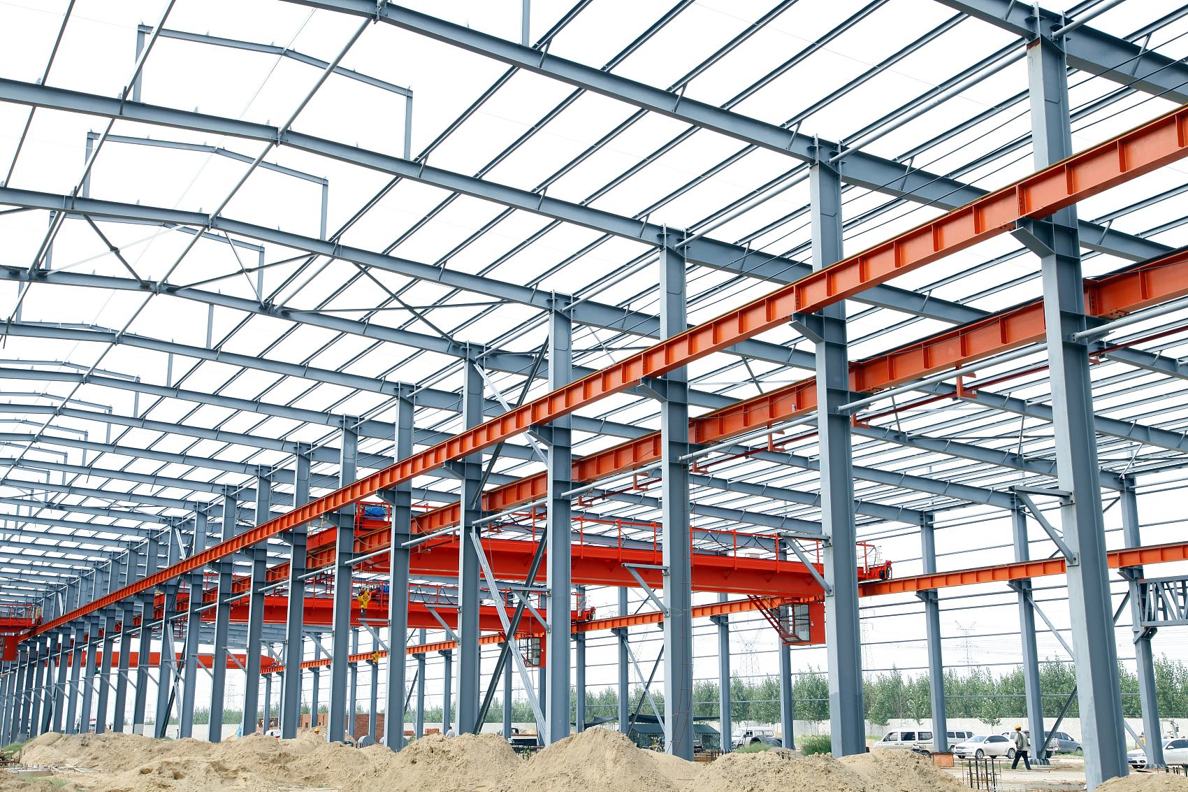 Interior structural steel framing showing tapered portal rafters cold-formed Z-purlins and diagonal flange bracing