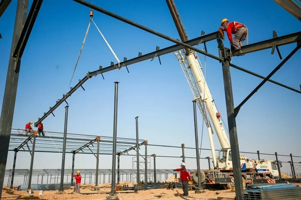 Workers assembling prefabricated steel structure chicken coop
