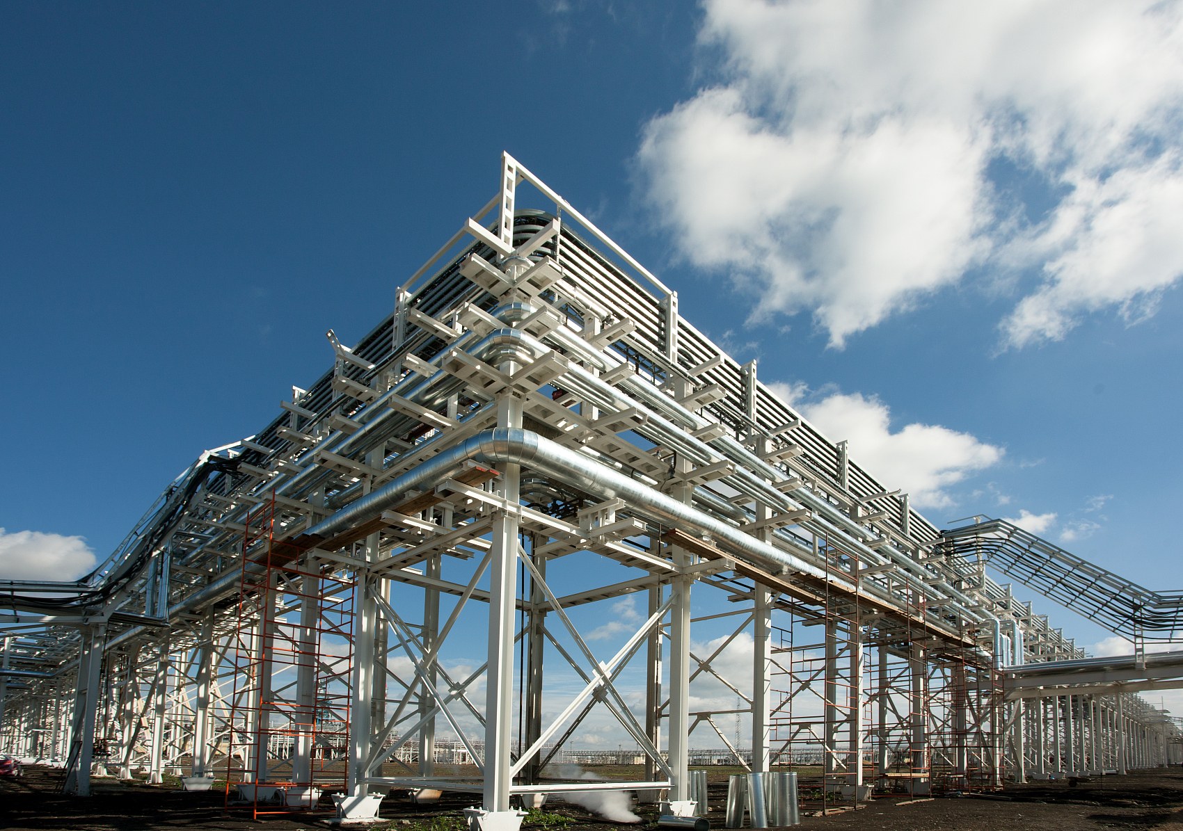 Erected industrial galvanized portal frame steel structure featuring clear-span tapered rafters and rigid haunch moment connections under daylight
