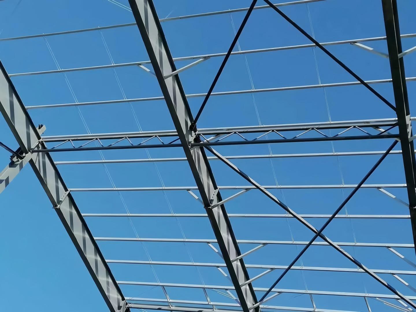 Structural steel portal frame knee haunch connection showing deep tapered plate girder web stiffeners and diagonal lateral torsional buckling purlin kickers