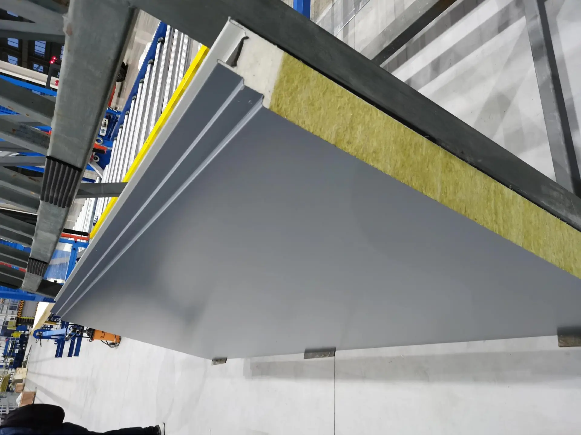 Cross-section detail of industrial cladding sandwich panel cores showing rigid PIR closed-cell foam, oriented mineral rockwool lamellas, and Galvalume steel skin