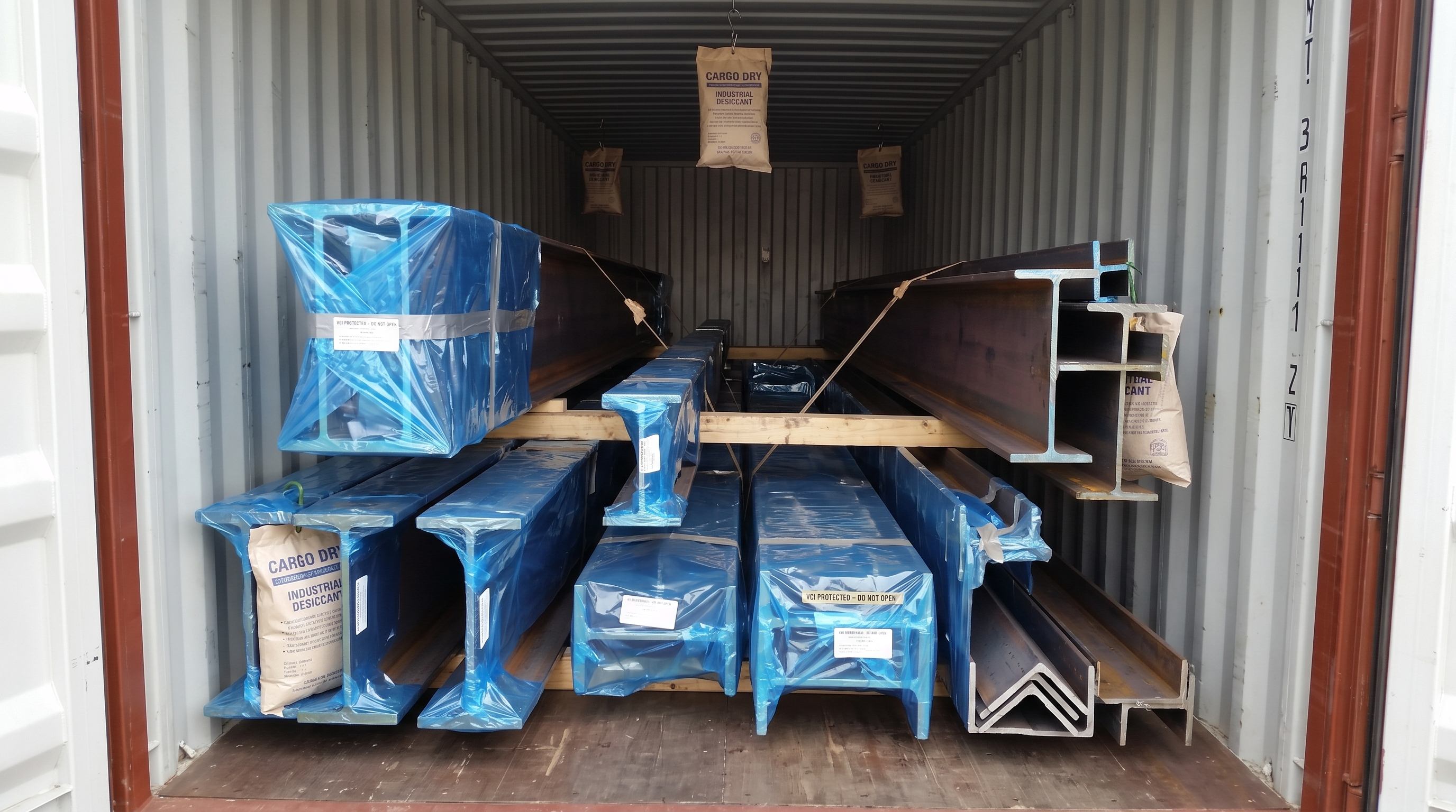 VCI protective wrapping and industrial desiccant bags on structural steel framing inside shipping container
