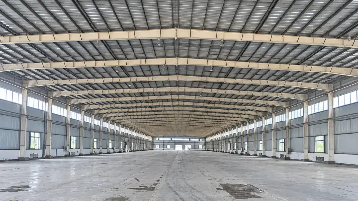 Prefab steel structure warehouse interior with high-cube clear span steel frame under construction